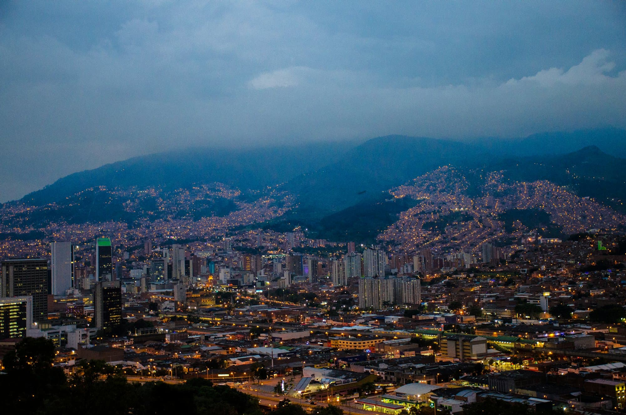 Medellín al atardecer, con las luces de los barrios subiendo por las laderas